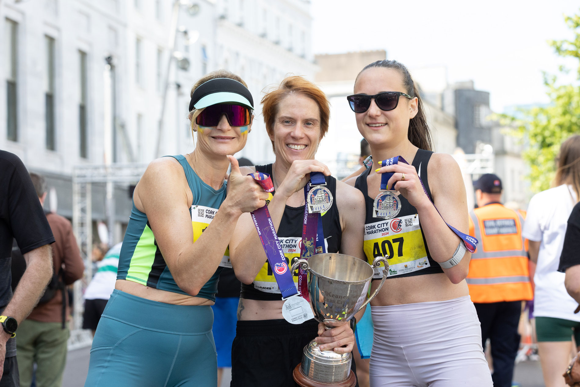 Three runners with trophy and medals