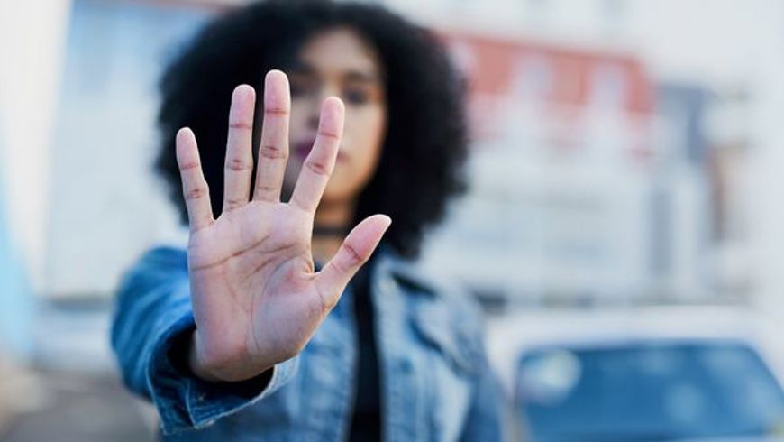 image of woman holding her hand palm first to the camera in a stop gesture