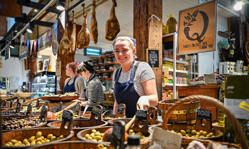 A woman serving olives at a market