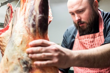 Employee examining preserved meat