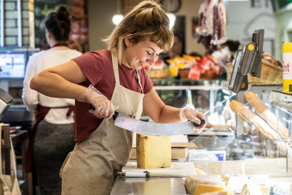 Employee slicing cheese